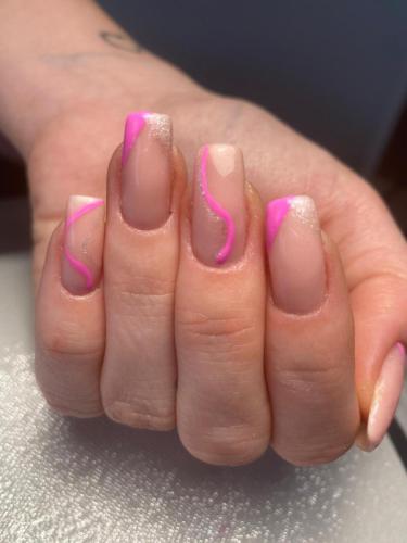 femme avec mains vernies par maud institut avec du nail art rose sur du transparent
